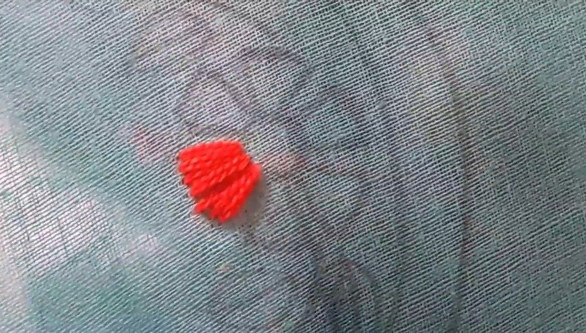 using orang thread to stitch the flower petal